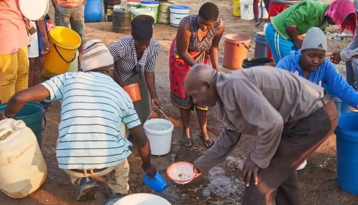 People are seen filling their pots in Zimbabwe. — AFP File