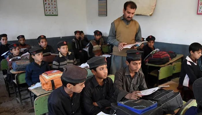 This photo shows children attending a class at a school in Peshawar. — AFP/File
