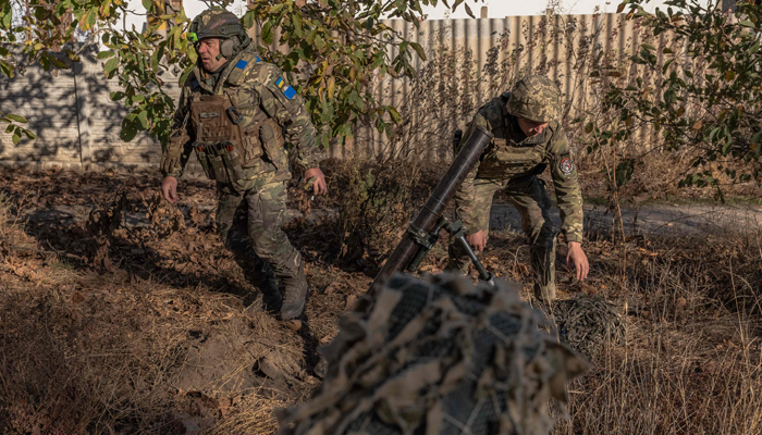 Ukrainian servicemen in action while firing a mortar over the Dnipro River toward Russian positions, in an undisclosed location in the Kherson region, on November 6, 2023. — AFP