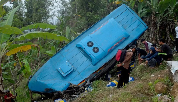 Indonesian people look at the wreckage of a bus after it crashed and plunged into a ravine in Sukabumi region, West Java. — AFP/File