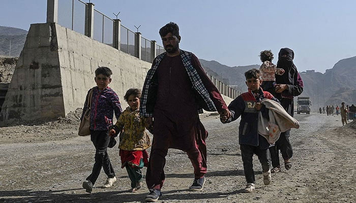 An Afghan refugee family arrives on foot to cross the Pakistan-Afghanistan Torkham border on November 2, 2023, following Pakistan´s government decision to expel people illegally staying in the country. — AFP