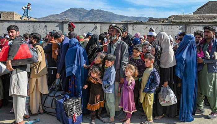 Afghan refugees wait in a queue to cross the Pakistan-Afghanistan border in Torkham on October 27, 2023. — AFP