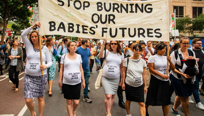 The image shows women protesting against the government over steps that contribute to extraordinarily hot conditions in New South Wales. — AFP File