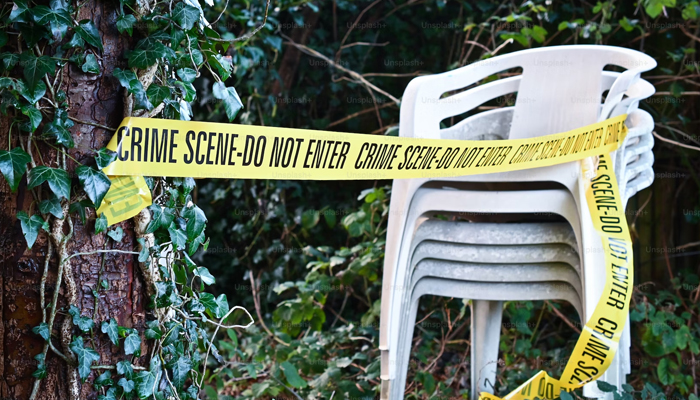 This image shows a police tape wrapped on a chair. — Unsplash/File
