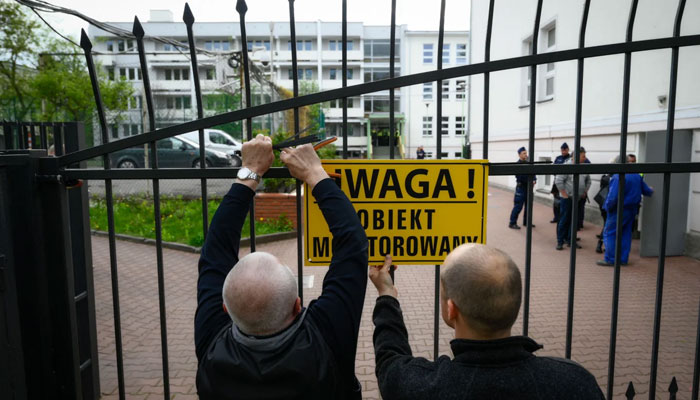 City officials put up a warning sign on the gate of a Russian embassy in Warsaw, Poland on April 29. — AFP File