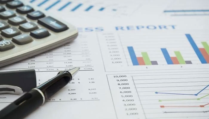 A representational image of business reports kept beside a pen and calculator. — Canva/File