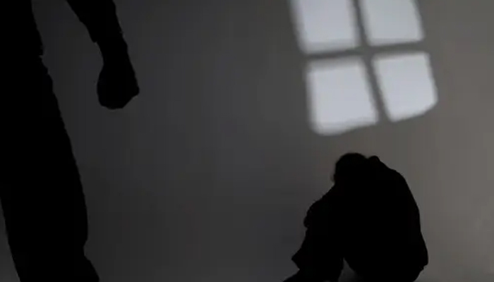 A representational image shows a shadow of a person making fist with another shadow of a person sitting humiliated. — Unsplash/File