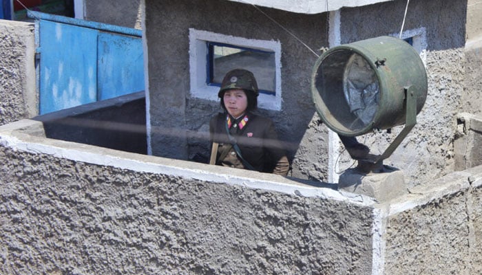 The image released on April 2018, shows a North Korean soldier at a guard post. — NK News