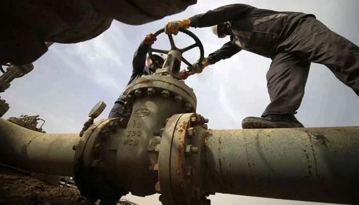 Two employees work on a gas pipeline. — AFP/File
