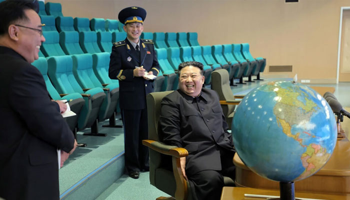 North Korea state media said leader Kim Jong Un (R) is already reviewing spy satellite images of military bases in the South. —AFP File