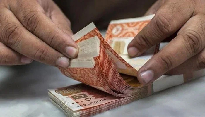 Money changer counts Rs5,000 notes. — AFP/File