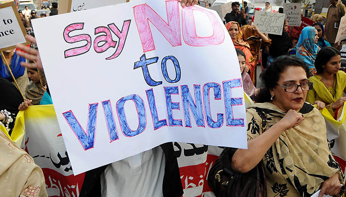 Women can be seen holding placards during a rally on violence against women in Lahore. — AFP/File