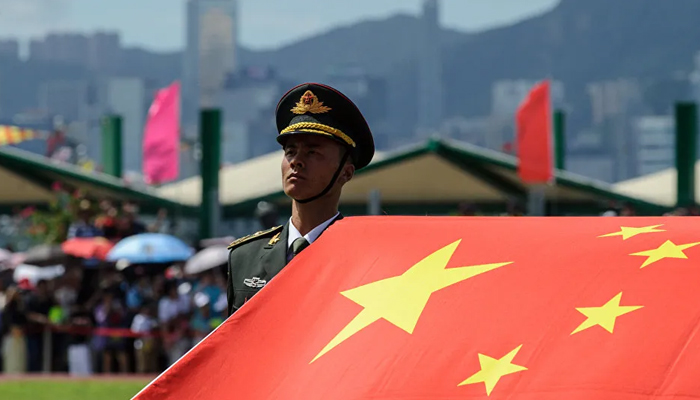 A PLA honour guard beside a Chinese flag at Stonecutters Bay naval base near Hong Kongs Victoria Harbor. — AFP/File