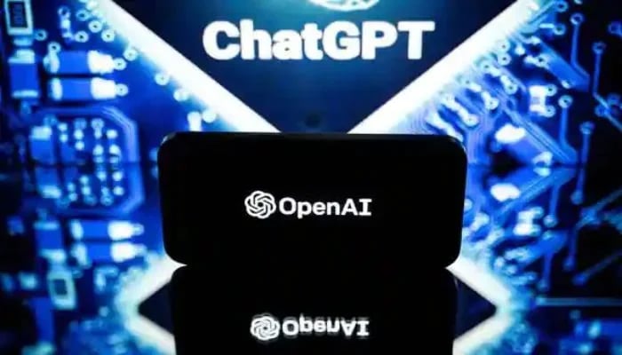 ChatGPT can be seen written in the background as a mobile screen shows the generative AI company OpenAI.— AFP/File