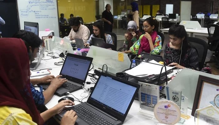 This photograph shows women working alongside men at their stations at the National Incubation Centre (NIC), in Lahore. — AFP/ File