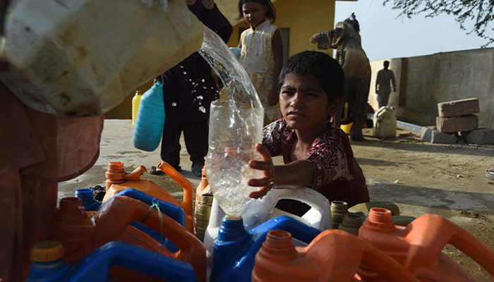 A girl fills her bottle from a water distribution point in Karachi. — AFP/File