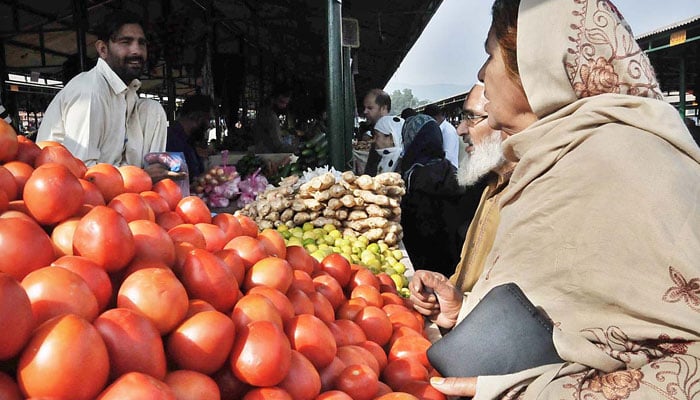 People purchasing vegetables from a vendor at the weekly Sunday Bazaar, Aabpara on Nov 19, 2023. — APP