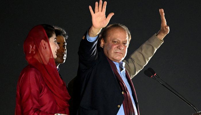 Former Prime Minister Nawaz Sharif (R) stands beside his daughter Maryam Nawaz (L) as he waves to his supporters in Lahore on October 21, 2023. — AFP