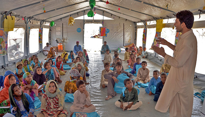 Internally displaced flood-affected children attend a class at a makeshift school at Dera Allah Yar in the Jaffarabad district of Balochistan. — AFP/File