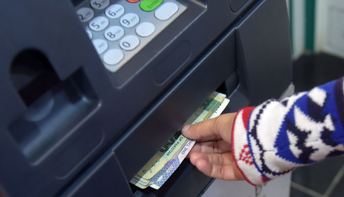 A person withdraws cash from an ATM in Pakistan. — AFP/File