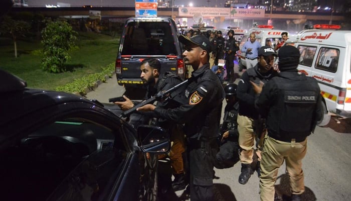 Policemen take position near the site of an attack on a police compound in Karachi on February 17, 2023. — AFP