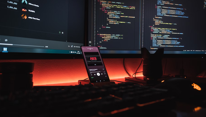 A representational image shows a mobile phone connected to a large screen showing different algorithms. — Unsplash/File