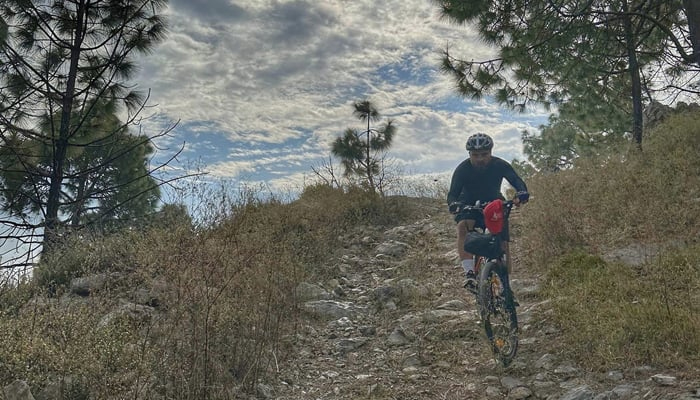 This image released on November 19, 2023, shows a person cycling on tracks on the hills of Margalla in Islamabad. — Facebook/MTB Islamabad