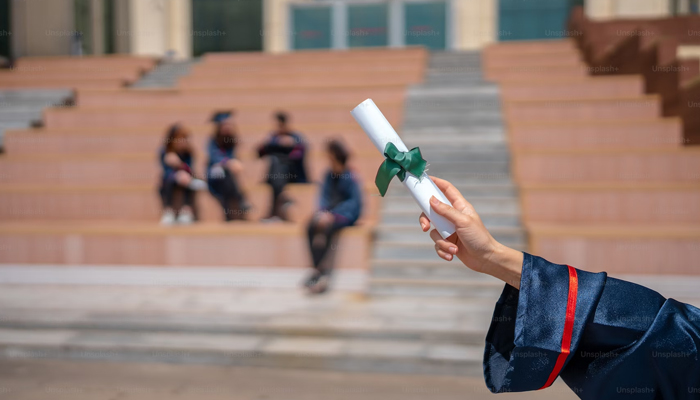 This image shows a person holding a diploma certificate. — Unsplash/File