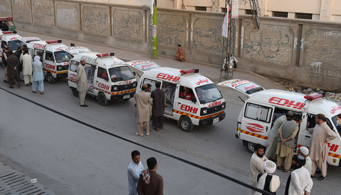 This image shows a number of ambulances parked on a road with rescue officials standing alongside the vehicles. — AFP/File
