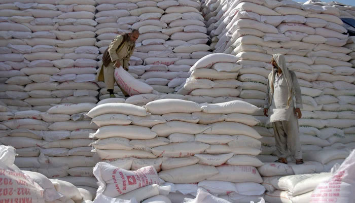 Workers load sugar sacks in Islamabad on June 8, 2023. — Online
