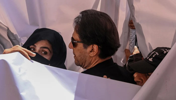 Former Pakistan prime minister Imran Khan (C) with his wife Bushra Bibi (L) arrive to appear at a high court in Lahore on May 15, 2023. — AFP