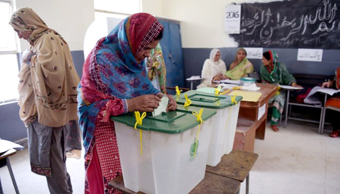 A woman casts her vote during the general election at a polling station in Islamabad. — AFP/File