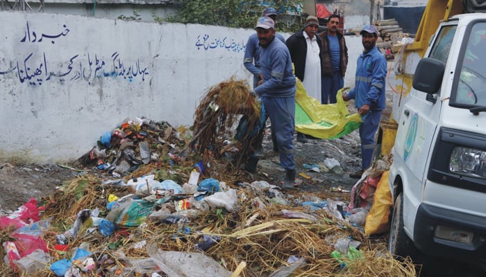 WASSCA workers clean a dumping site in this image on November 26, 2023. — Facebook/Water & Sanitation Services Company Abbottabad