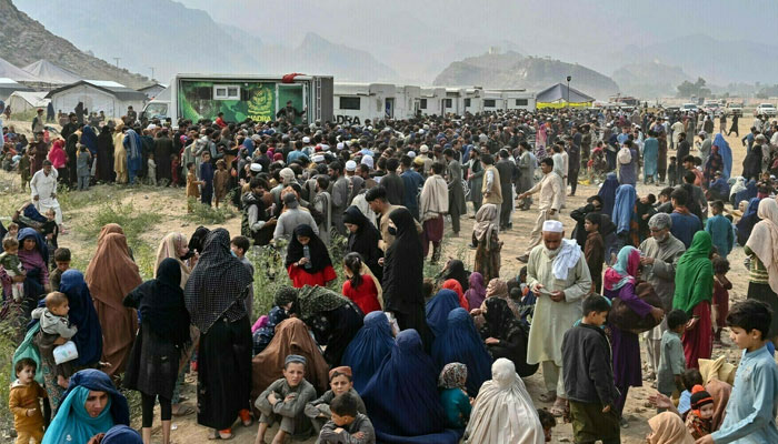 Afghan refugees gather around National Database and Registration Authority (Nadra) vans for biometric verifications as they prepare to depart for Afghanistan, at a holding centre in Landi Kotal on Nov 1. — AFP