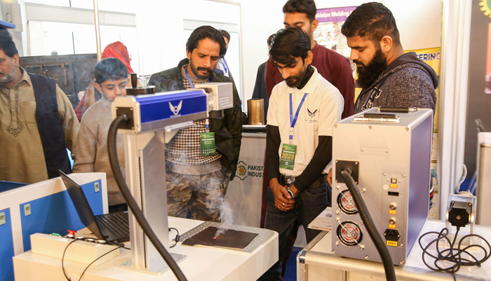 People look toward a machine during the 7th Pakistan Industrial Expo at the Lahore Expo Centre on November 26, 2023. — Facebook/TMC Technologies
