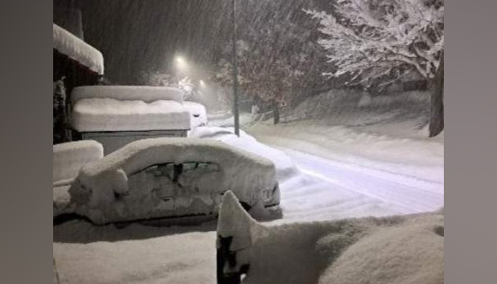 This image released on December 2, 2023, shows heavy snowfall in the German city of Munich with cars covered in a white snow blanket. — X/@unwetterfreaks