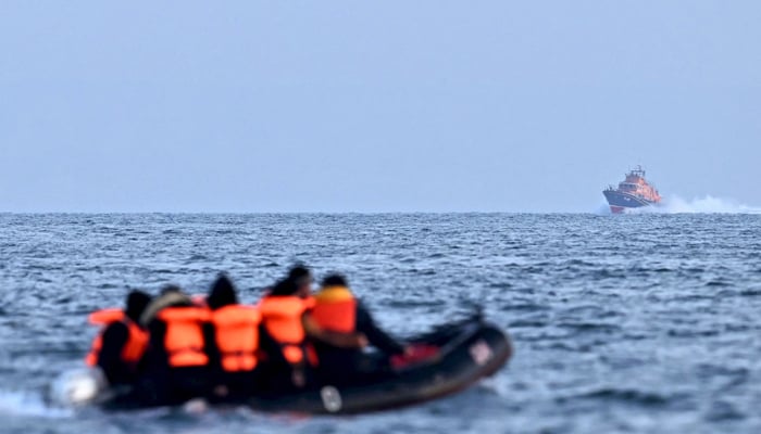 Royal National Lifeboat Institution Severn class lifeboat, the City of London II, makes its way towards migrants travelling in an inflatable boat across the English Channel, bound for Dover on the south coast of England. — AFP/File