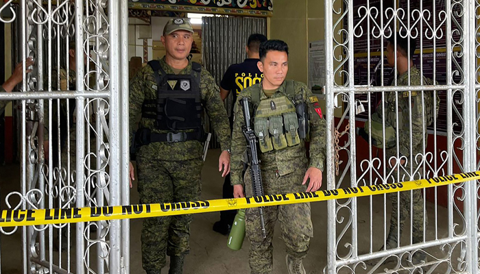 Military personnel stand guard at the entrance of a gymnasium while police investigators look for evidence after a bomb attack at Mindanao State University in Marawi, Lanao del sur province on December 3, 2023. — AFP