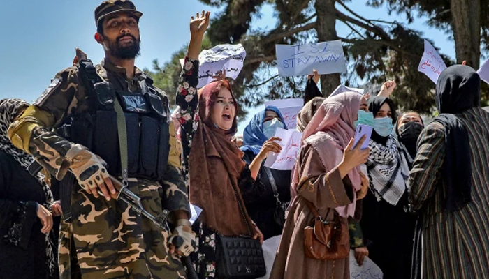 A Taliban fighter stands guard as Afghan women shout slogans during a protest rally in Kabul. — AFP/File
