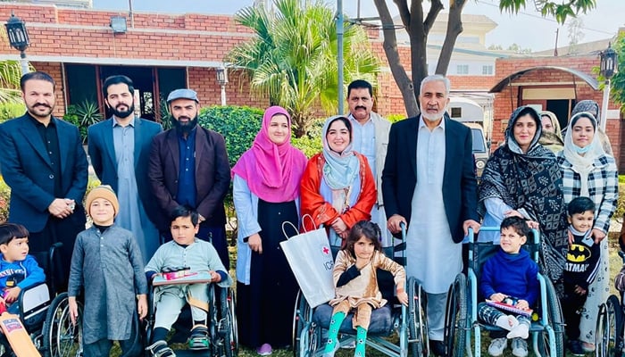 Dr Syed Muhammad Ilyas (3rd-L), CEO of the Paraplegic Centre Peshawar poses for a group photo alongside children on the occasion of the International Day of Persons with Disabilities on December 3, 2023. — Facebook/Paraplegic Center Peshawar