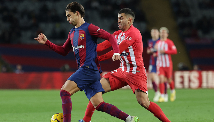 Barcelonas Joao Felix (L) is challenged by Atletico Madrids Angel Correa during the Spanish league football match between FC Barcelona and Club Atletico de Madrid at the Estadi Olimpic Lluis Companys in Barcelona on December 3, 2023. — AFP