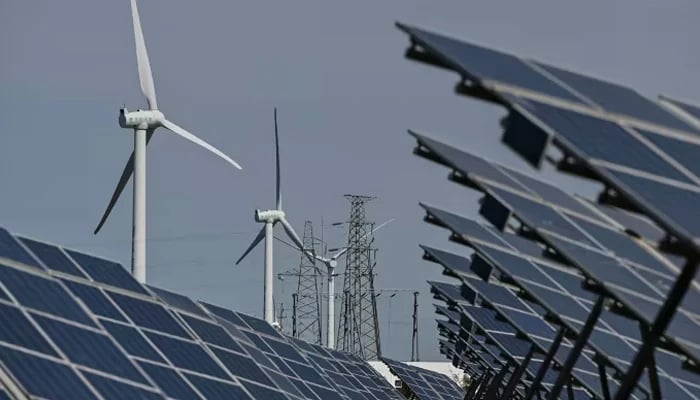 Electric power generating wind turbines and solar panels can be seen. — AFP/File
