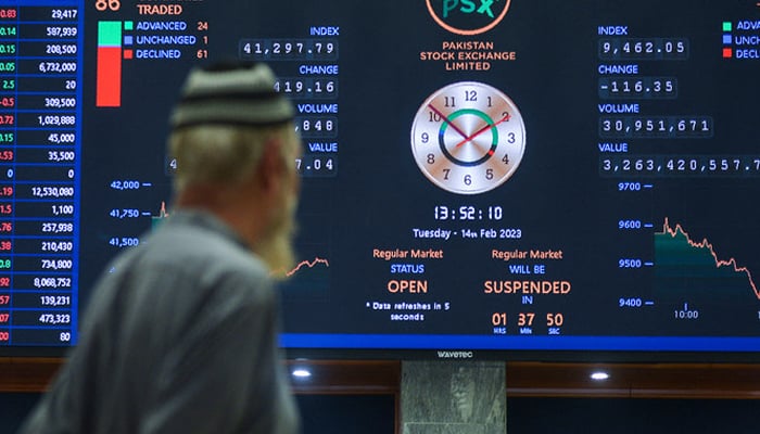 A broker looks at an index board showing the latest share prices at the Pakistan Stock Exchange in Karachi. — AFP/File