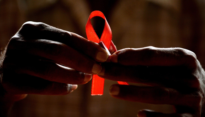 A person prepares red ribbons on the eve of World Aids Day in Bangalore. — AFP/File