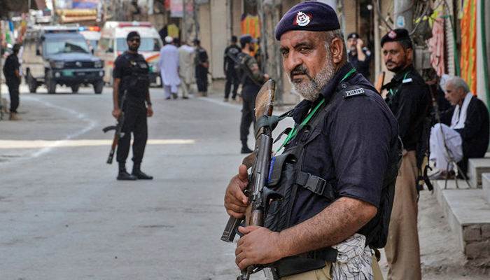 This image shows Peshawar police personnel standing guard on a road. — AFP/File
