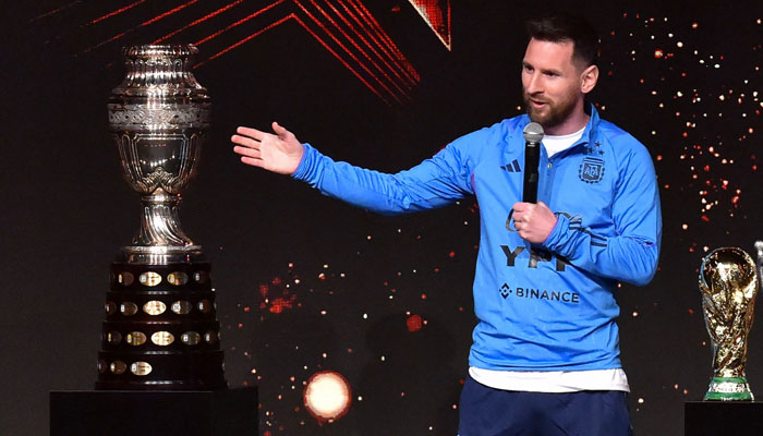 Lionel Messi delivers a speech between the Copa America trophy (L) and a replica of the World Cup, during a tribute by Conmebol to the members of the Argentine national team for winning the Qatar 2022 World Cup.— AFP/File