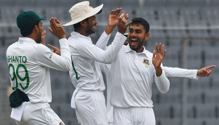Bangladeshs Mehidy Hasan Miraz (R) celebrates with teammates after taking the wicket of New Zealands Devon Conway (not pictured) during the first day of the second Test cricket match between Bangladesh and New Zealand at the Sher-e-Bangla National Cricket Stadium in Dhaka on December 6, 2023. — AFP