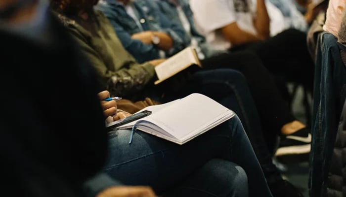 A representational image shows participants in a conference with a diary. — Unsplash/File