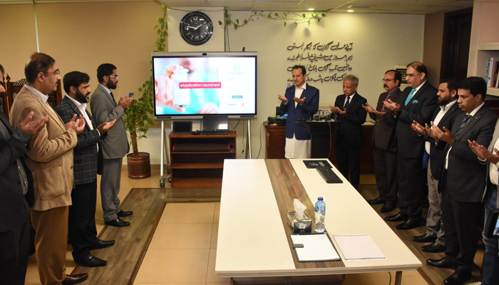 Federal health minister Dr Nadeem Jan prays during the launch of a mobile application for online registration and licensing of drugs on December 6, 2023. — Facebook/Ministry of National Health Services, Regulations & Coordination Islamabad
