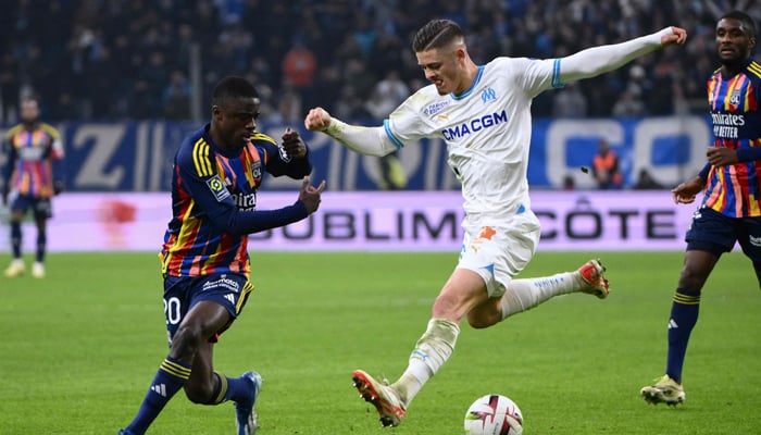 Marseilles Portuguese forward Vitinha (R) and Lyons French defender Sael Kumbedi (L) fight for the ball during the French L1 football match between Olympique Marseille (OM) and Olympique Lyonnais (Lyon) at the Stade Velodrome in Marseille, southern France on December 6, 2023. — AFP